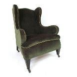 A Georgian style wingback arm chair with camel back, upholstered wings, arms and stuffed overseat,