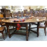 A large oak oval drop leaf dining table, raised on turned supports. l. 168 cm, w. 220 cm