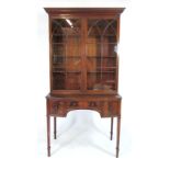 A Regency style mahogany bookcase on base, a pair of doors with arching astragal glazing on a bow