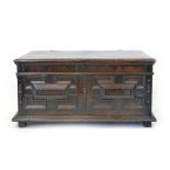 An oak coffer, possibly late 17th century and later, hinged cover enclosing a re-lined interior