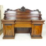 A Victorian mahogany twin pedestal sideboard, foliate carved gallery above a full width shelf on