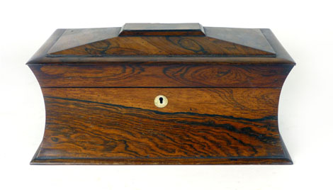 An early 19th Century rosewood tea caddy of sarcophagus form with fitted interior of a pair of