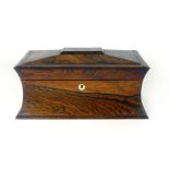 An early 19th Century rosewood tea caddy of sarcophagus form with fitted interior of a pair of