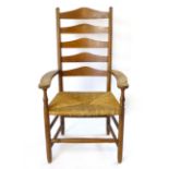 After Gimson, an ash ladder back arm chair by Neville Neal with shaped arm rest, rush seat and