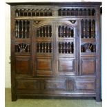 An oak floor standing food cupboard, 18th Century and later, dental cornice above an open gallery,