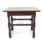 An oak side table, late 17th century and later, cleeted top above block and turned legs and