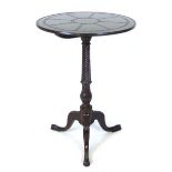 A mahogany circular tilt top occasional table, carved top above a wrythen and foliate carved