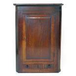 A George lll oak wall hanging corner cupboard with fielded panel door above one true and two false