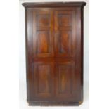 A mahogany floor standing corner cupboard, late 18th/early 19th century, two pairs of panelled doors