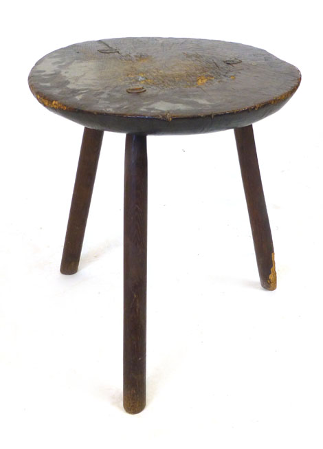 A primitive oak tripod table, adzed circular top on slightly tapering legs.  h. 49 cm, CONDITION