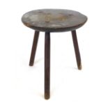 A primitive oak tripod table, adzed circular top on slightly tapering legs.  h. 49 cm, CONDITION