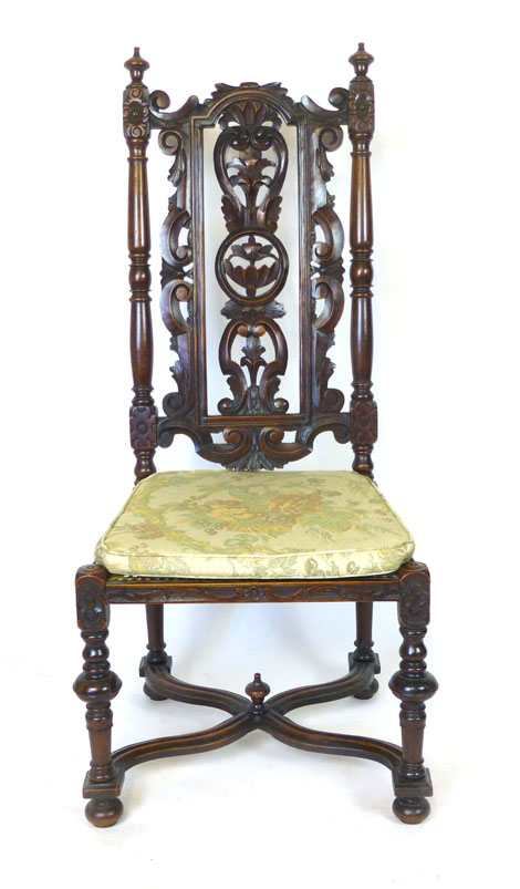 A Carolean style oak chair with scrolling, foliate, pierced back above a cane seat, turned legs