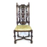 A Carolean style oak chair with scrolling, foliate, pierced back above a cane seat, turned legs