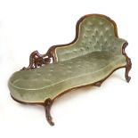 A Victorian walnut framed chaise longue with buttoned back, serpentine seat and scrolling legs. l.