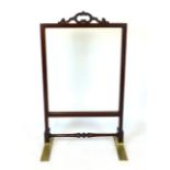 A Victorian mahogany fire screen, pierced handle above a clear glass screen, turned stretcher and