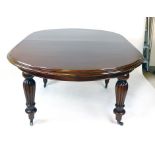 A Victorian mahogany windout extending dining table, with oval top and reeded baluster legs, with