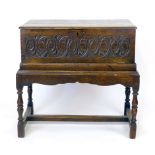 An oak bible box on stand, late 17th century and later, two plank top above a carved and  hinged