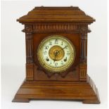 An Ansonia mantle clock, the circular ivorine dial with Arabic numerals in mahogany case, h. 36