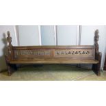 A Victorian oak pew with foliate carved ends, scrolling pierced back solid seat,  l. 257 cm