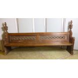 A Victorian oak pew with foliate carved ends, trellis pierced back and solid seat,  l. 253 cm