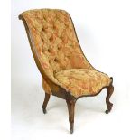 A 19th century walnut button back nursing chair with a serpentine seat and short cabriole legs