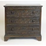 An oak chest of three drawers with arching foliate carving,  h. 72 cm, w. 77 cm CONDITION REPORT: