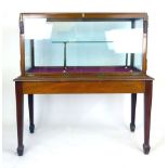 A mahogany framed glazed display cabinet on a table base with tapering square section legs and an