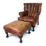 A modern leather wing back chair with a loose cushion, scrolling legs and claw and ball feet