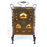 An Arts & Crafts style copper and wrought iron fire screen with stylized foliage repousse