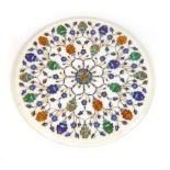 An Agra marble and semi precious stone inlaid circular table top decorated with stylized flower