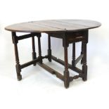 An 18th century and later oak gateleg dining table, the plank top raised on a turned and block