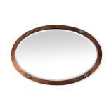 An Arts and Crafts hammered copper oval mirror,