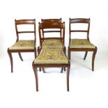 A set of four Regency mahogany sabre leg dining chairs, with needlework drop in seats, h.