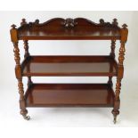 A Victorian mahogany three tier buffet with carved gallery and turned supports,