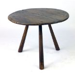 An oak cricket table, the planked circular top on three chamfered and splayed legs,