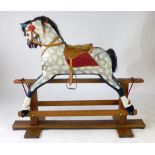 A dappled grey rocking horse with a hair mane and tail, leather saddle and tackle on a pine base, h.