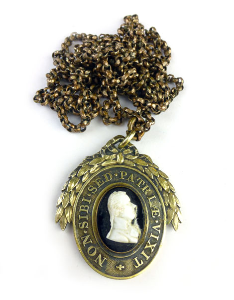 A gold plated belcher link muff/guard chain suspending a yellow metal mourning pendant of oval form