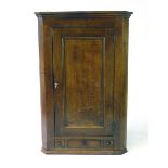 A George III oak wall hanging corner cupboard, with a single panelled door above three drawers, h.