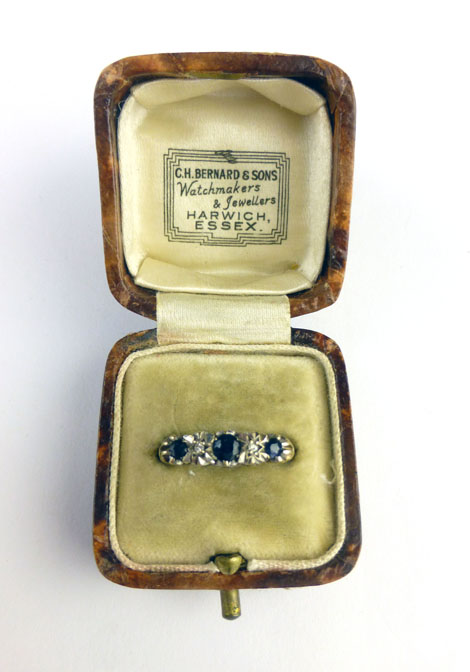 A 9ct yellow gold ring set three graduated sapphires interspersed with two small diamonds within a