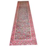 ANTIQUE HERIZ RUNNER, 396cm x 101cm, circa 1910, repeat polychrome motifs on bistre field.