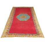 MOROCCAN CARPET, 300cm x 195cm, of an azure central medallion on ruby field and multiple borders.
