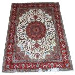 PART SILK TABRIZ, 210cm x 154cm, central medallion in claret on an ivory field with spandrels and a