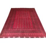 VINTAGE AFGHAN CARPET, 348cm x 264cm, elephant feet guls on a ruby field within multiple bands and