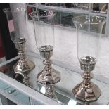 TABLE CANDLE LIGHTS, a set of three, plated metal on raised bases, with removable glass tops,