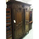 ARMOIRE, late 18th century French oak and foliate carved of two doors enclosing shelves,