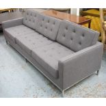 SOFA, with grey felt upholstery on polished metal supports, 230cm W x 78cm D x 78cm H.