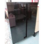 CABINET, in black lacquer with internal shelves on square supports,