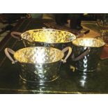 ICE BUCKETS, a set of three, hammered silver plate of oval form with leather handles,