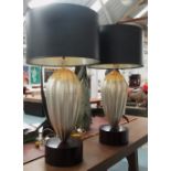 SIDE LAMPS, a pair, having silvered shaped bases with black shades, 86cm H overall.