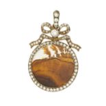 An Edwardian diamond and agate set pendant of circular outline with applied ribbon motif, set